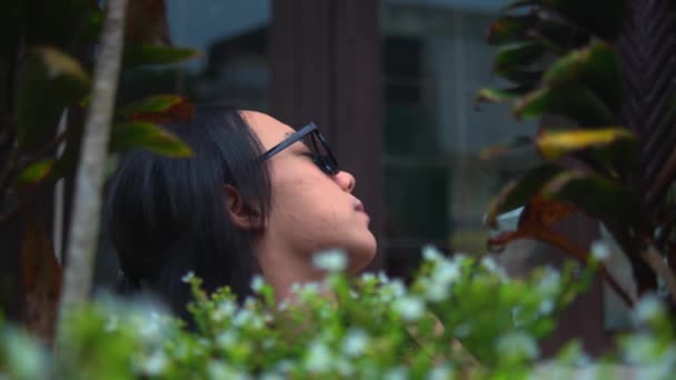 Adolescente Asiático Está Sentado Muito Perto Das Flores Jardim Pela — Vídeo de Stock