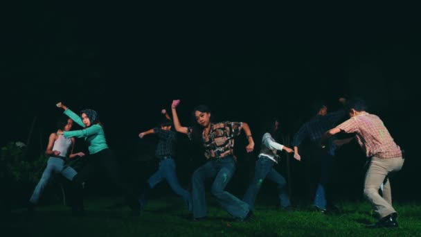 ヴィンテージの服を着たアジア人のグループが夜に友人たちと一緒に色の粉で踊りました — ストック動画