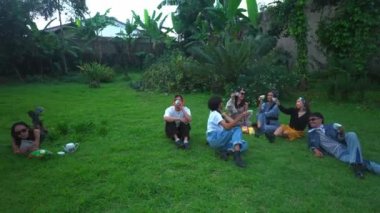 Baharda yeşil bir parkta arkadaşlarıyla çay içen bir grup Asyalı genç.