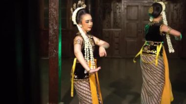 Bir grup Javalı dansçı akşam şovu için makyaj yaparken birlikte dans ediyorlar.