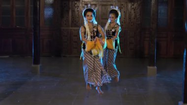 Bir grup Sundanlı dansçı, geceleri bir tahta tapınakta geleneksel bir dans yarışmasına katılıyorlar.