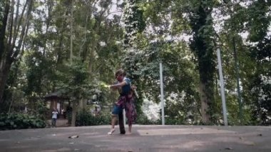 Şapka ve dans kostümü giymiş Endonezyalı bir dansçı öğle vakti elleri sahnenin ortasında dans eder.