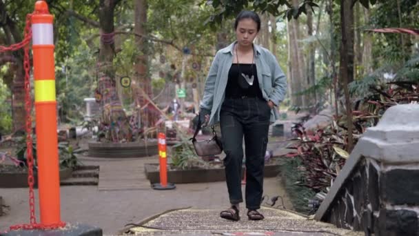 Egy Fekete Ruhás Ázsiai Sétál Egyedül Egy Fákkal Teli Parkban — Stock videók