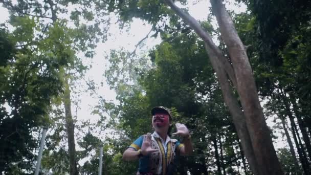 赤いマスクと青いコスチュームのダンスを持つアジアのダンサーは 朝の森の真ん中に非常に敏捷です — ストック動画
