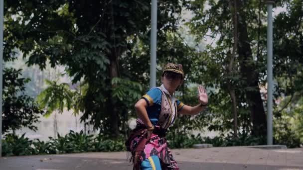 Индонезийская Танцовщица Шляпе Танцевальном Костюме Танцует Руками Центре Сцены Полдень — стоковое видео