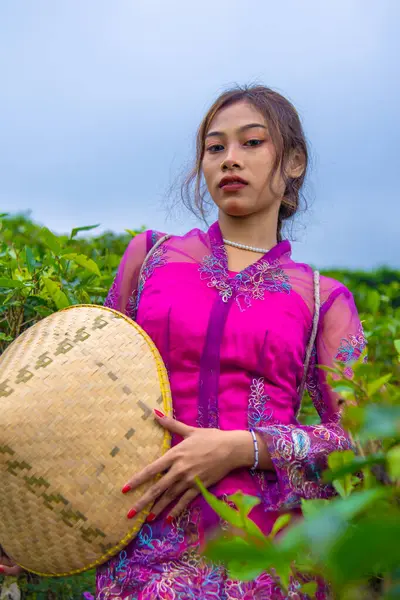一名身穿粉色连衣裙 手里拿着竹帽的印尼妇女 — 图库照片
