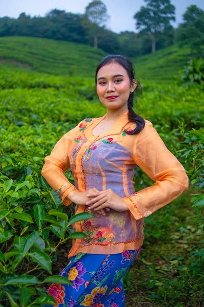 Seorang Petani Daun Teh Dengan Gaun Oranye Berpose Depan Taman — Stok Foto