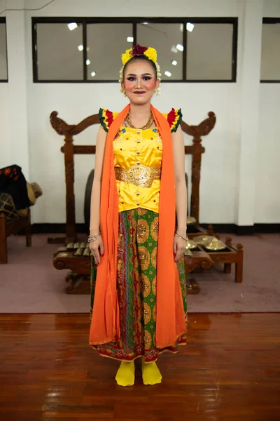 Tradycyjna Indonezyjska Tancerka Stojąca Żółtym Kostiumie Pomarańczowym Szaliku Zwisającym Jej — Zdjęcie stockowe