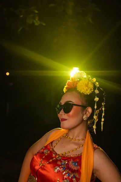 Санданская Танцовщица Позирует Перед Сияющим Светом Оранжевом Костюме Солнцезащитными Очками — стоковое фото