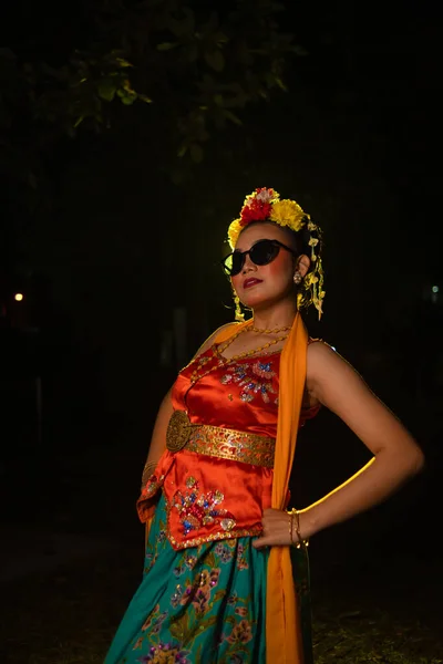 Tancerka Sundańska Pozuje Przed Świecącym Światłem Pomarańczowym Kostiumie Okularami Przeciwsłonecznymi — Zdjęcie stockowe