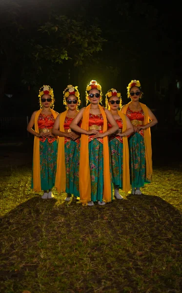 一群印度尼西亚传统舞蹈家与他们的朋友在晚上的舞台灯光前跳舞 — 图库照片
