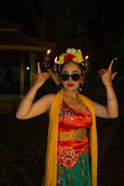 夜にサングラスを着用しながら 非常に美しい手の動きで踊るジャワの伝統的なダンサーの肖像画 — ストック写真