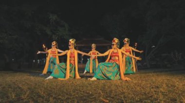 Geleneksel Java kıyafeti ve güneş gözlüğü takmış beş kadın dansçı gece vakti meşalelerle aydınlatılmış senkronize bir gösteri sergiliyorlar. Kültür ve modern serinliğin eşsiz bir birleşimi.