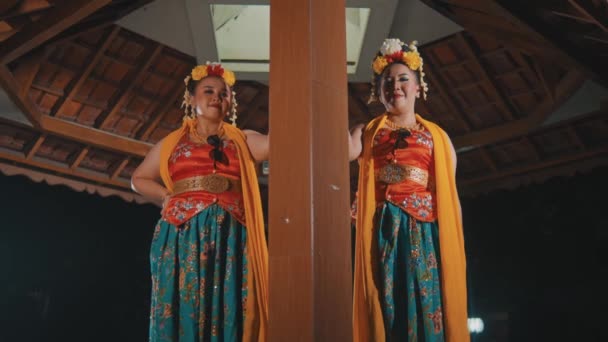 Дві Традиційні Яванські Танцюристи Стоять Між Стовпами Коричневого Павільйону Носячи — стокове відео