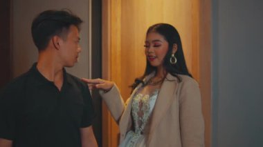 Elbise ve ceket giymiş şık bir Asyalı kadın otel odasının kapısında bir adamla duruyor. Sessizlik ya da sır için işaret vermek için parmaklarını dudaklarına koyar ve uzaklaşıp gider..