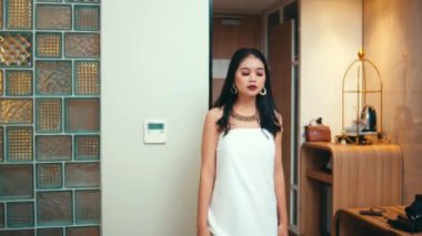 Beyaz havluya sarılmış bir kadın, otel odasına açık kapıdan yeni giren bir adamı tanımak için dönüyor..