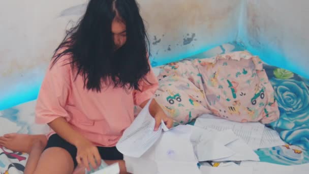 ストレスを感じた顔をしたアジア人女性が 部屋の紙の廃棄物を一日中 — ストック動画