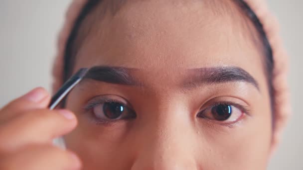 一位美丽的亚洲女人早上在梳妆台前化妆得像个眼线笔 脸上涂着红唇 — 图库视频影像
