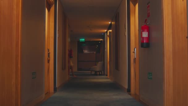 一位酒店游客走在一条黄昏时分的走廊上 寻找着一个夜晚的房间 — 图库视频影像