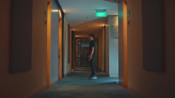 Hotel Visitor Walks Hallway Full Yellow Lights Looking Room Night — Stock Video