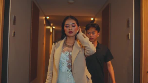 夜のホテルの廊下で彼女のボーイフレンドと歩いている熱いアジアの女性 — ストック動画