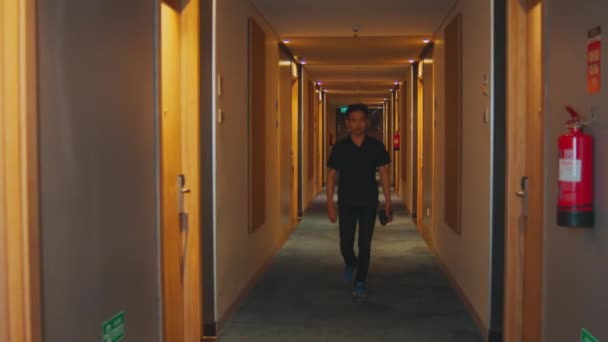 Een Hotelbezoeker Loopt Door Een Gang Vol Gele Lichten Zoek — Stockvideo