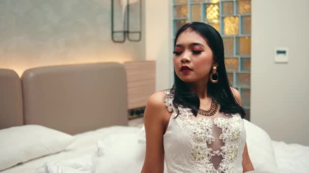 Una Mujer Asiática Vestido Blanco Sienta Una Cama Mira Sarcásticamente — Vídeos de Stock