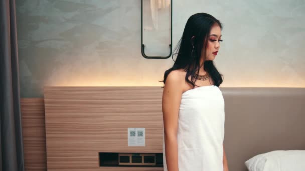 Μια Ασιάτισσα Που Φοράει Λευκή Πετσέτα Ένα Δωμάτιο Ξενοδοχείου Ενώ — Αρχείο Βίντεο