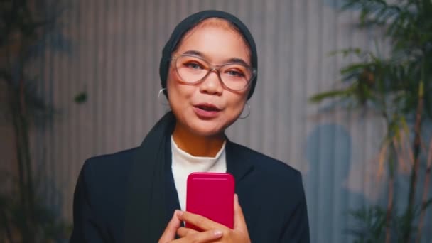 Asiatisk Kvinna Bandanna Och Glasögon Pratar Med Kameran Med Växt — Stockvideo