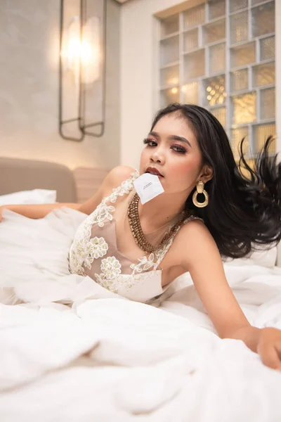 Seorang Wanita Asia Dengan Rambut Pirang Dan Gaun Putih Menggigit — Stok Foto