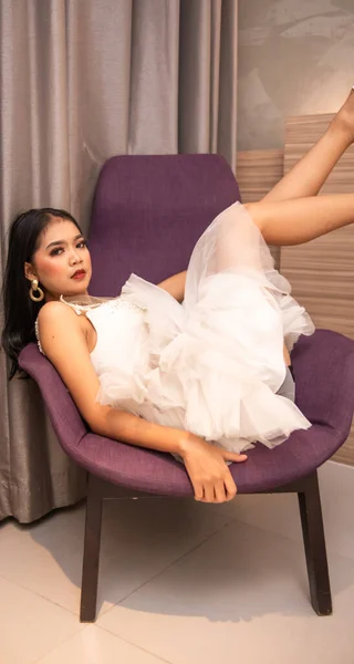 Азиатка Сексуальном Белом Платье Лежит Диване Гладкими Ногами Номере Отеля — стоковое фото