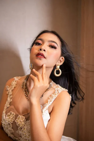 白いドレスと黒の髪を持つアジアの女性は 夜のホテルの部屋でセクシーでエレガントなポーズをしています — ストック写真