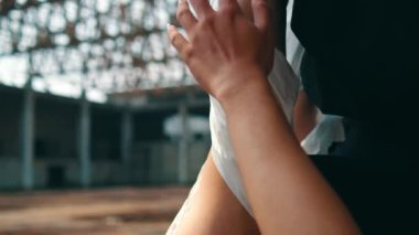 Asyalı bir adam, öğleden sonra boş bir binada elinde asılı duran bir kişinin cesedine dokunuyor.
