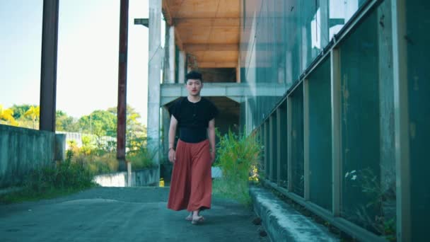 アジア人男性が放棄された建物のガラスの窓を一日中歩き回っています — ストック動画