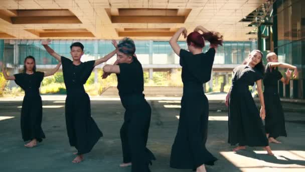 一群亚洲舞蹈家在白天穿着黑色服装 身体轻盈地跳舞 — 图库视频影像