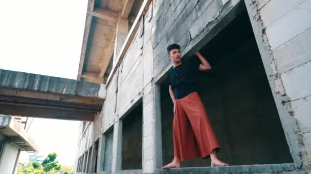 Ein Asiatischer Mann Der Tagsüber Mit Traurigem Gesicht Einer Betonmauer — Stockvideo