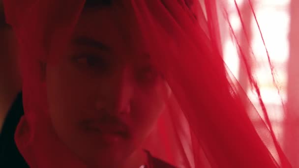 一名身穿红衣的亚裔男子 白天在窗前轻盈轻盈地跳着舞 — 图库视频影像