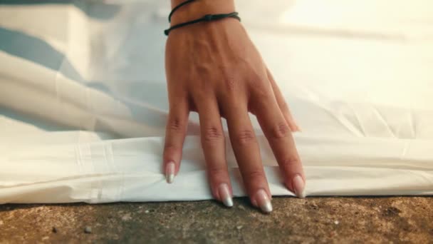 Рука Азиата Поднимает Белую Ткань Лежащую Земле Держит Обеих Руках — стоковое видео