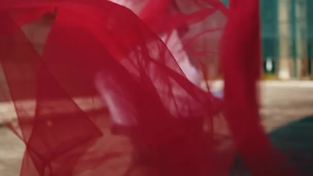 아시아 사람은 빨간색 천으로 실행하고 바람이 정오에 쾌활하게 — 비디오
