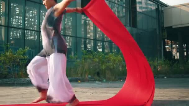 아시아 사람은 오래된 건물에있는 손으로 빨간색 흔들고있다 — 비디오