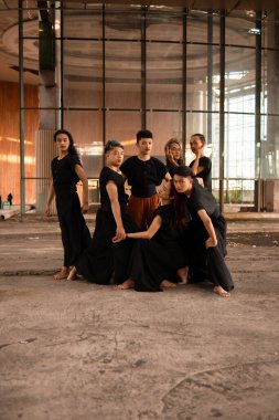 Bir grup Asyalı adam eski bir binanın önünde gün boyunca çeşitli pozlar verdiler.