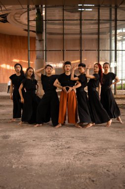 Bir grup Asyalı adam eski bir binanın önünde gün boyunca çeşitli pozlar verdiler.