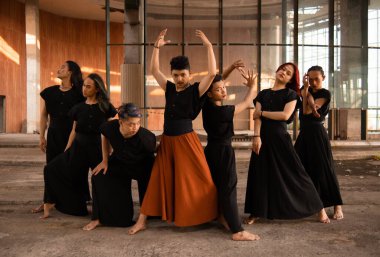 Bir grup Asyalı adam eski bir binanın önünde gün boyunca çeşitli pozlar verdiler.