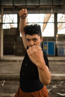 Asyalı bir adam bütün gün eski bir binanın önünde tek başına poz veriyor.