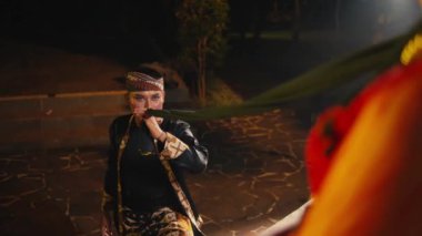 Asyalı bir adam siyah şalını çeker ve bir kadına çok romantik bir şekilde yaklaşır.