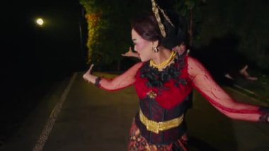 Ağaçlarla dolu çok canlı ve romantik bir sahnede dans eden bir çift ve geceleri sıcak ışıklar.