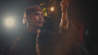 Asyalı bir adam siyah bir eşarp yakalar. Gece sahnede bir dansçı tarafından fırlatılır.