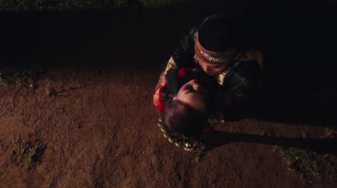 Bir çift aşık birbirine sarılıyor ve yerde öpüşüyorlar. Geceleri birbirlerine dik dik bakıyorlar.
