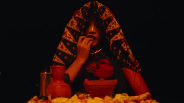 一个女人在夜晚在祭坛前举行令人生畏的仪式时 却在吃玫瑰 — 图库视频影像