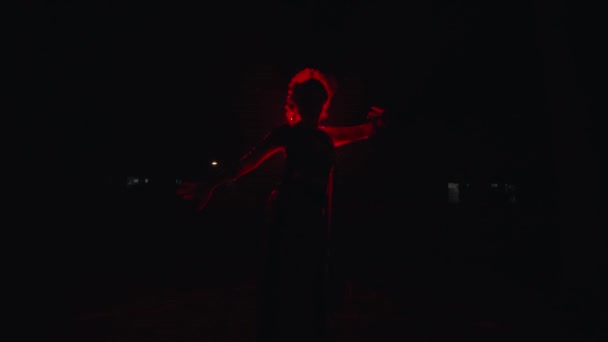 一个亚洲女人摆出在红灯前跳舞的姿势 晚上看起来很吓人 很恐怖 — 图库视频影像